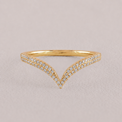 Gold ring with diamond accents on a beige background