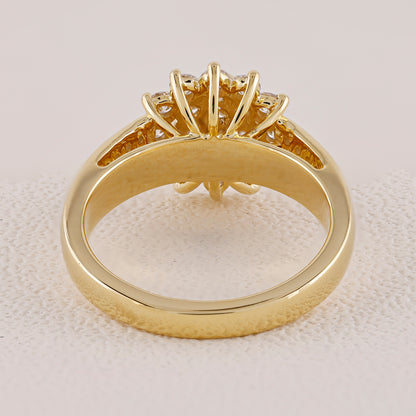 Gold ring with intricate design on a light beige background