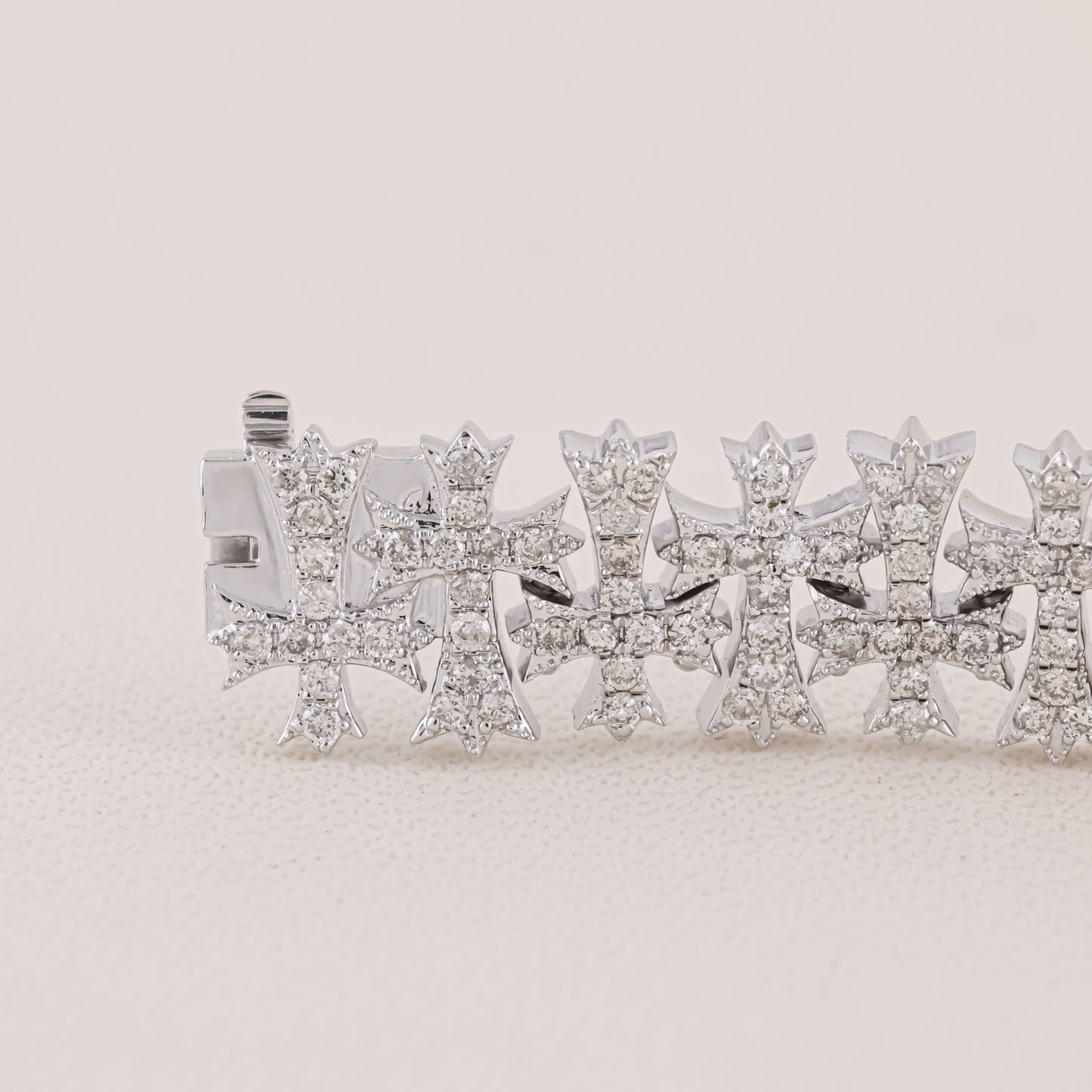 Silver bracelet with star-shaped charms on a light beige background