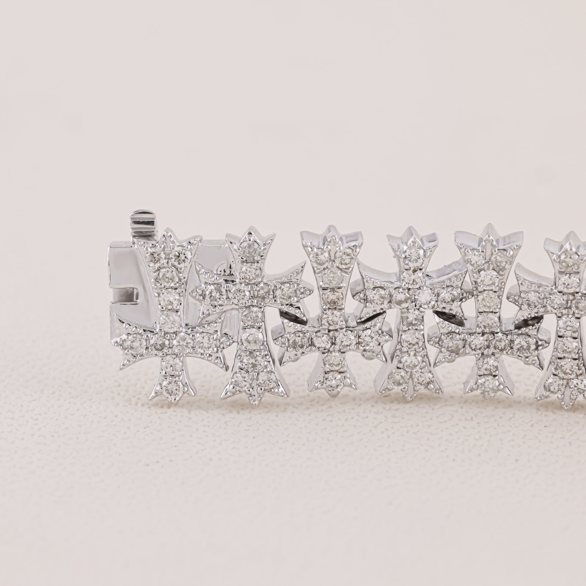 Silver bracelet with star-shaped charms on a light beige background